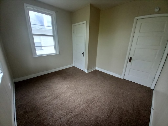 unfurnished bedroom featuring dark carpet