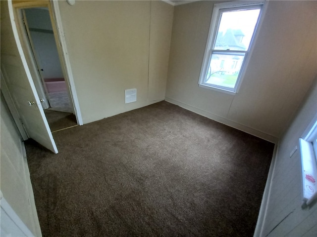 unfurnished room with dark carpet