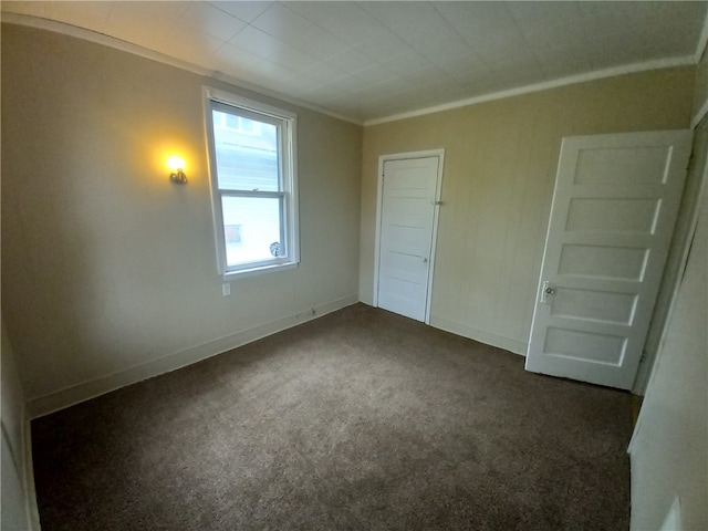 unfurnished bedroom with crown molding and dark carpet