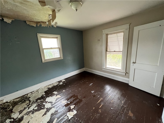 unfurnished room featuring dark hardwood / wood-style floors and plenty of natural light