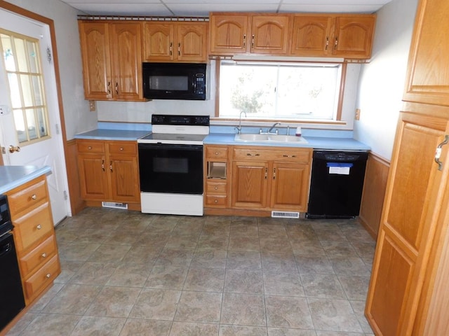 kitchen featuring sink, light tile flooring, and black appliances