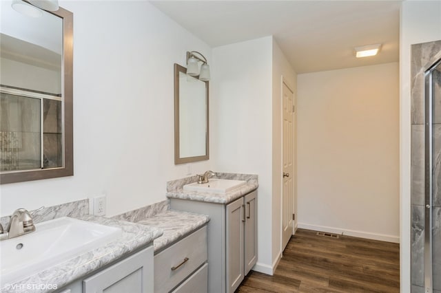 bathroom with vanity, walk in shower, and hardwood / wood-style floors