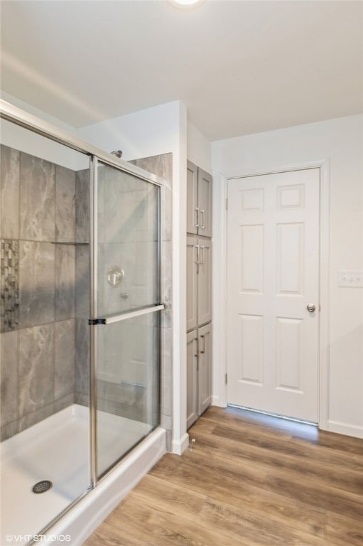 bathroom featuring a shower with door and wood-type flooring