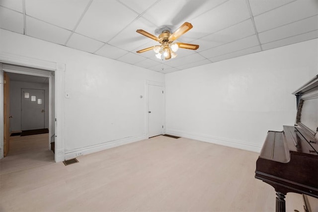 interior space with ceiling fan, a paneled ceiling, and light hardwood / wood-style floors