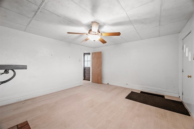 empty room featuring ceiling fan, light hardwood / wood-style flooring, and a drop ceiling