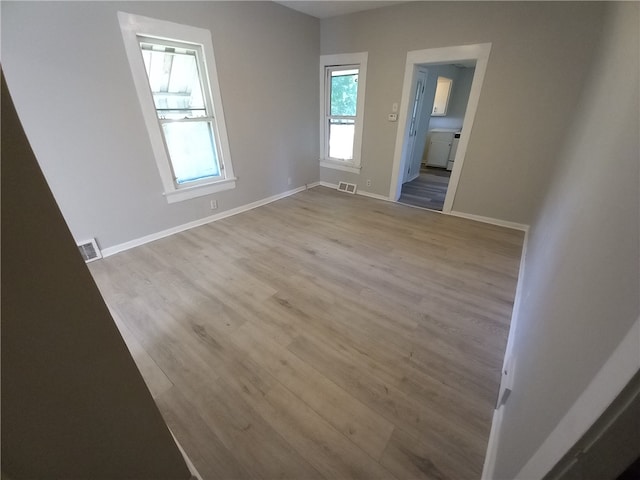 empty room featuring a wealth of natural light and light wood-type flooring