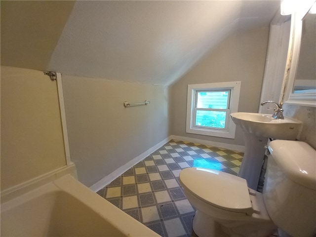 bathroom with lofted ceiling, a bathtub, and toilet