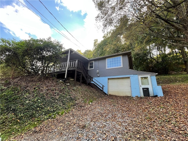 back of house featuring a deck and a garage