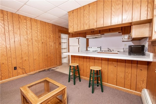 kitchen featuring light colored carpet, fridge, extractor fan, wood walls, and a drop ceiling