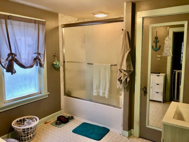 bathroom with enclosed tub / shower combo, tile floors, and vanity