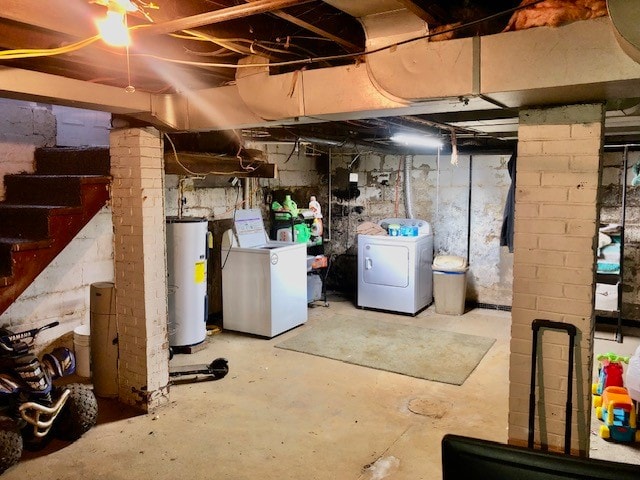 basement featuring gas water heater, separate washer and dryer, and brick wall