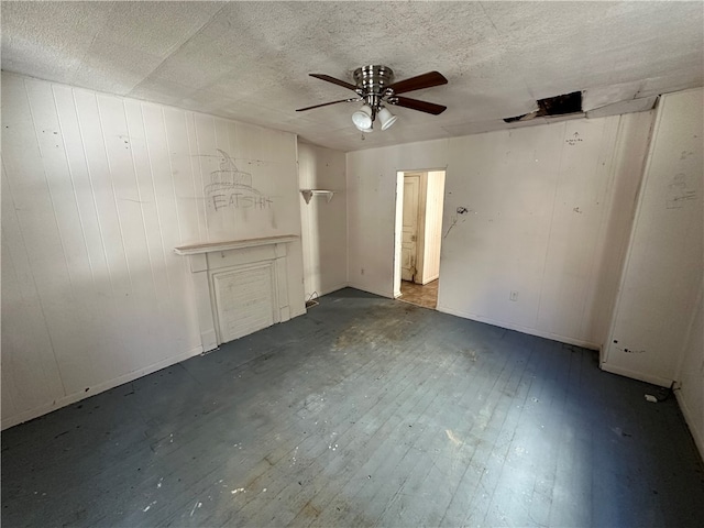 unfurnished bedroom featuring ceiling fan, dark wood-type flooring, and a textured ceiling