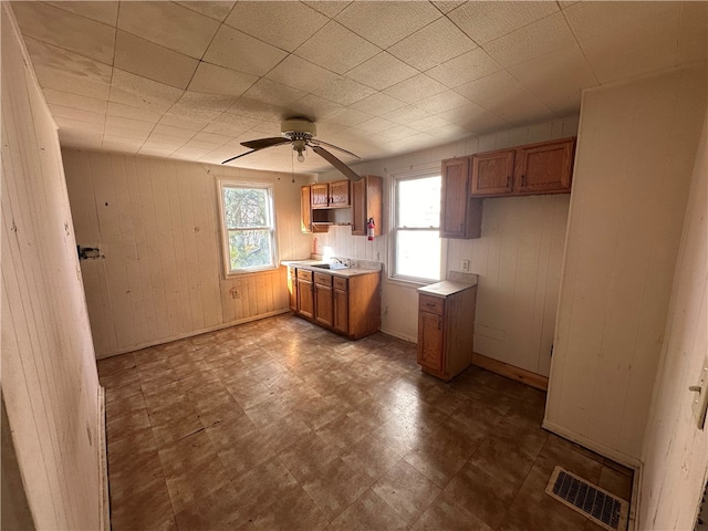 kitchen with sink, dark tile flooring, ceiling fan, and a healthy amount of sunlight