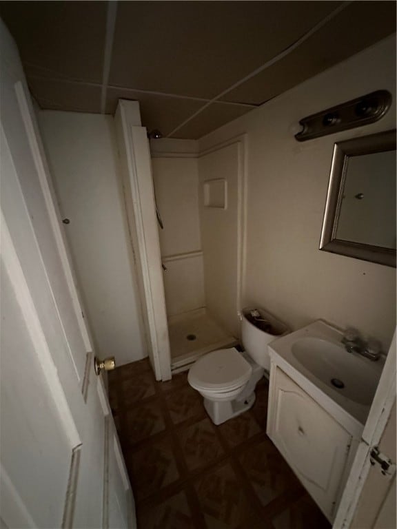 bathroom with walk in shower, toilet, vanity, and tile flooring