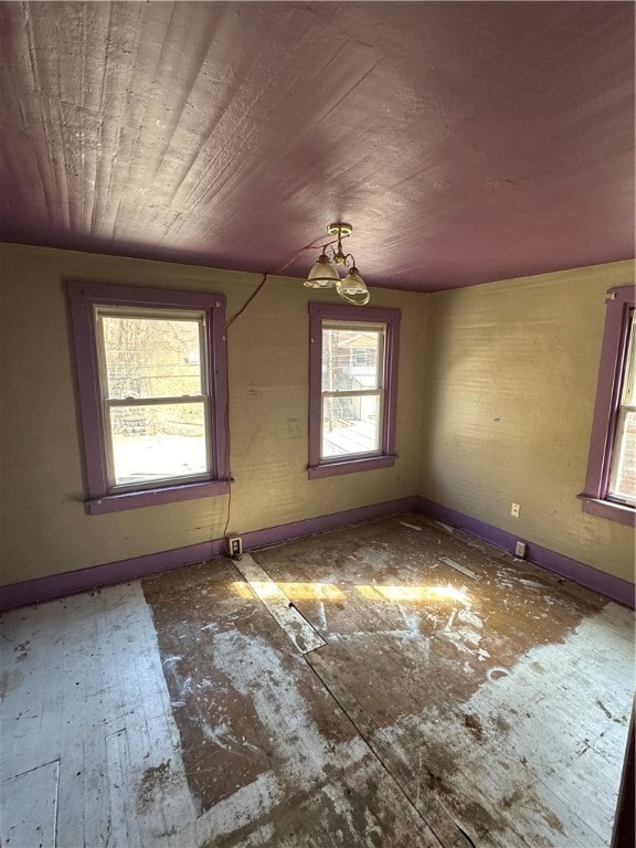 unfurnished room with an inviting chandelier and a wealth of natural light