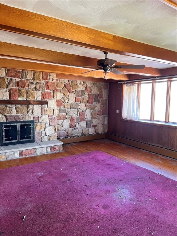 interior space with dark hardwood / wood-style floors, ceiling fan, a fireplace, beam ceiling, and baseboard heating