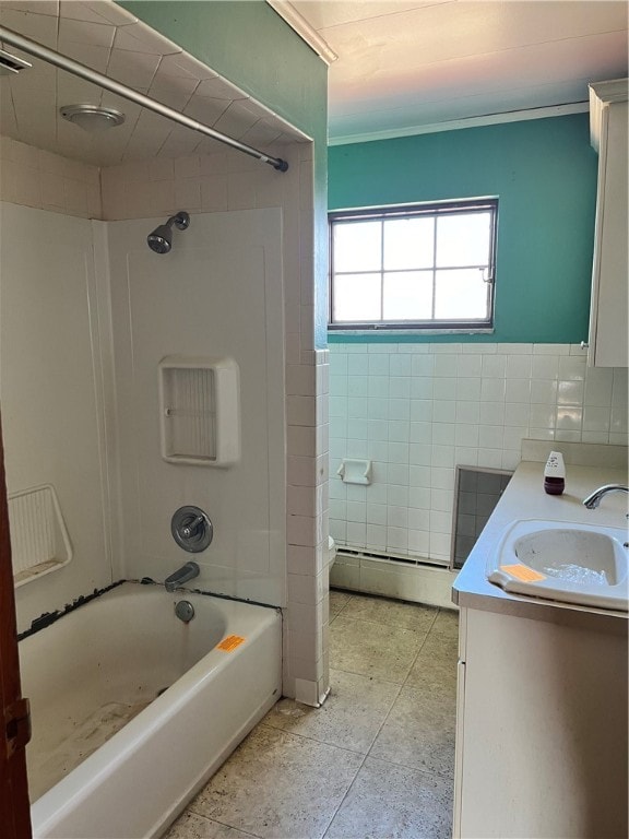 bathroom featuring vanity, tile walls, tile floors, a baseboard heating unit, and tiled shower / bath