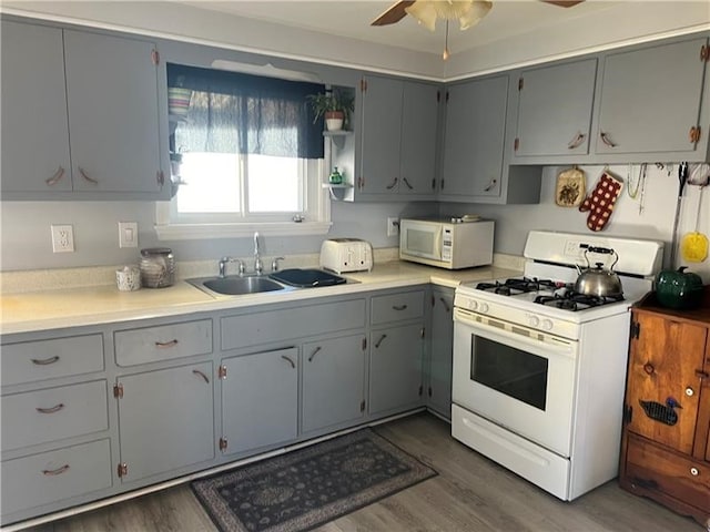 kitchen with sink, ceiling fan, dark hardwood / wood-style flooring, and white appliances