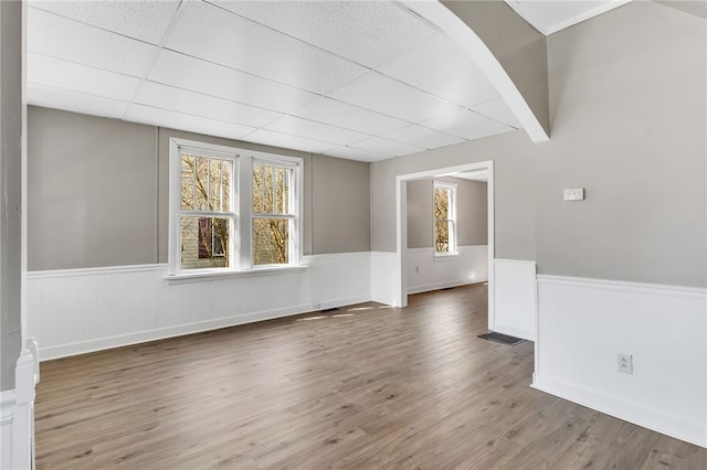 spare room featuring a drop ceiling and dark wood-type flooring