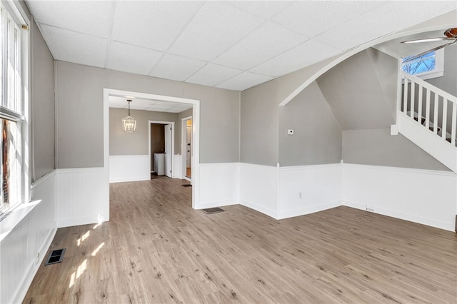 unfurnished room featuring plenty of natural light, a paneled ceiling, ceiling fan, and light hardwood / wood-style flooring