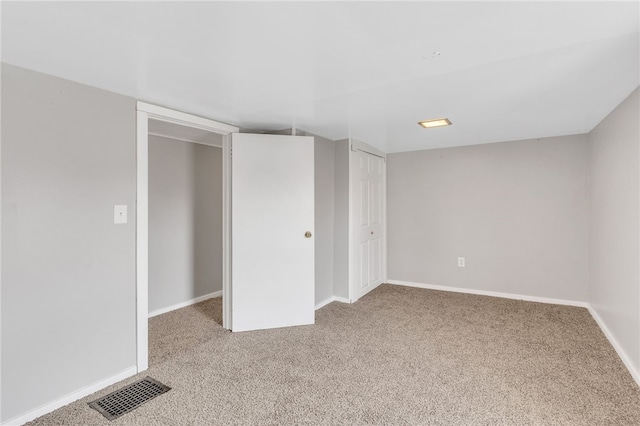 unfurnished bedroom with a closet and light colored carpet