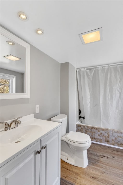 full bathroom featuring toilet, vanity, shower / tub combo with curtain, and wood-type flooring