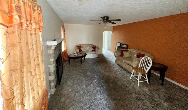 living area featuring a textured ceiling, carpet, and ceiling fan