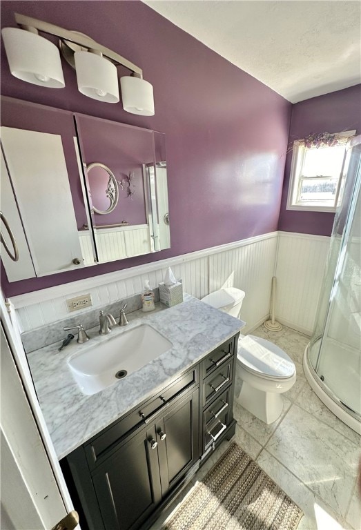 bathroom featuring toilet, tile flooring, an enclosed shower, and vanity with extensive cabinet space