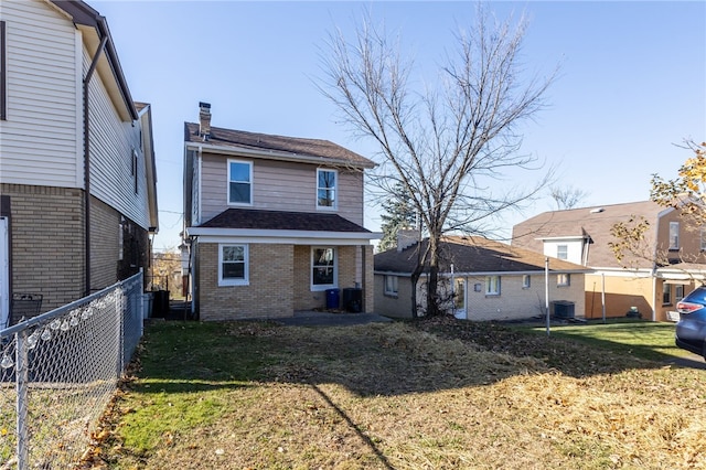 rear view of property with central AC and a lawn