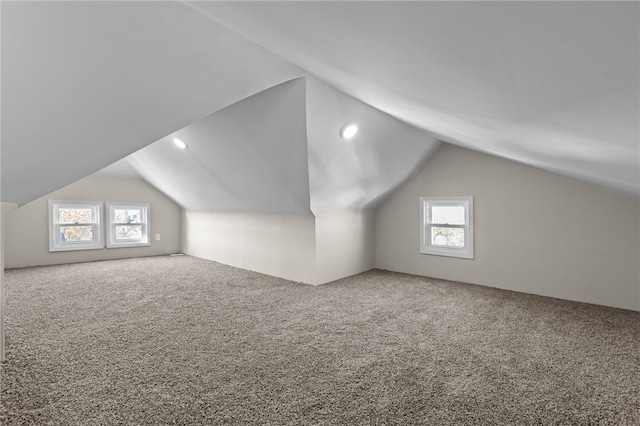 bonus room with lofted ceiling, plenty of natural light, and carpet floors