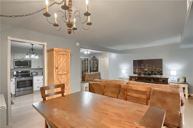 dining area featuring a notable chandelier and light wood-type flooring