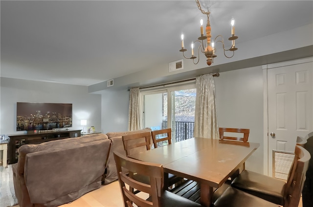 dining area with a chandelier and light hardwood / wood-style floors