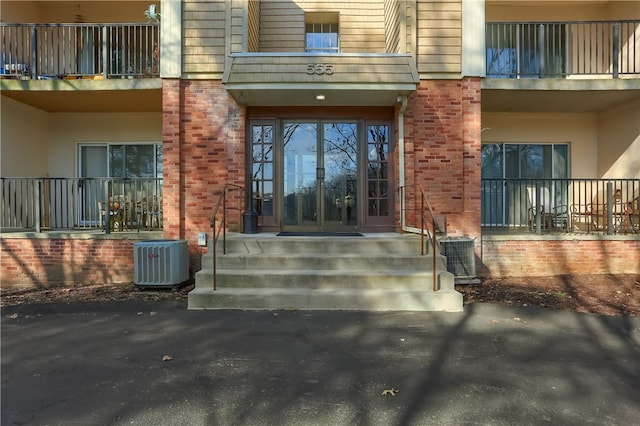 entrance to property featuring central air condition unit and a balcony