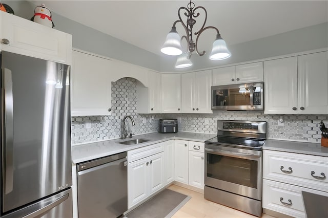 kitchen featuring a chandelier, decorative light fixtures, tasteful backsplash, appliances with stainless steel finishes, and sink