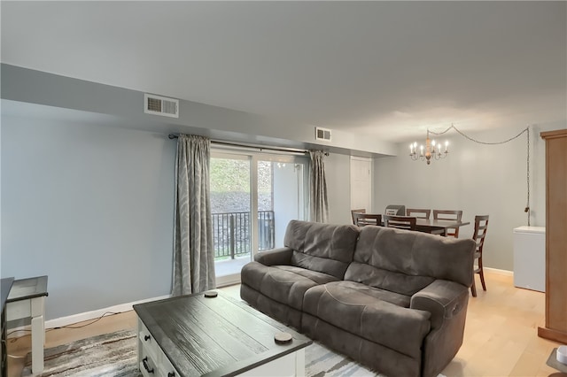 living room with an inviting chandelier and light wood-type flooring