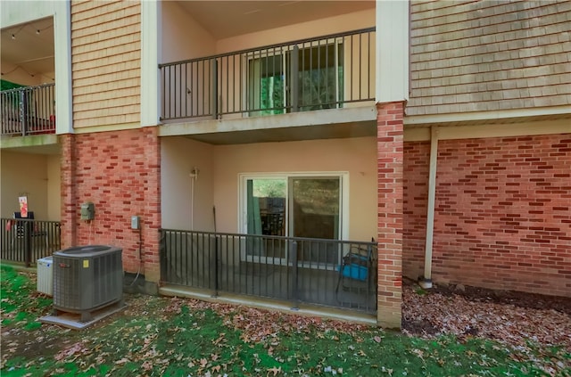 view of exterior entry featuring central air condition unit and a balcony