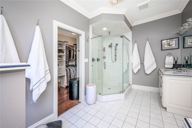 bathroom with crown molding, tile floors, a shower with shower door, and vanity