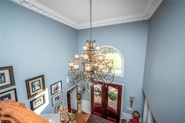 foyer entrance featuring a notable chandelier, crown molding, and hardwood / wood-style floors