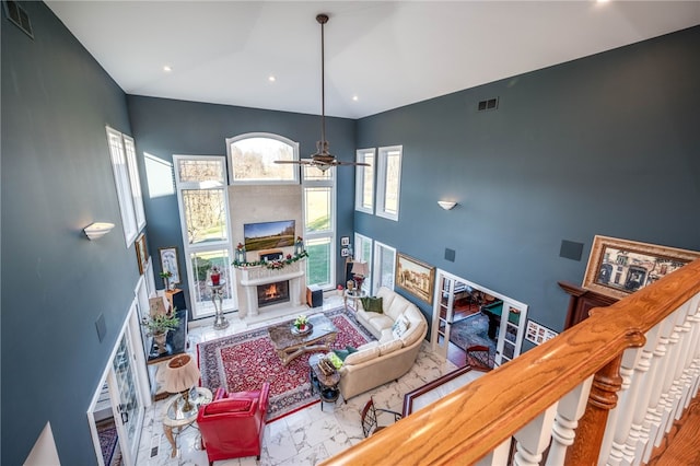 living room with ceiling fan and a high ceiling