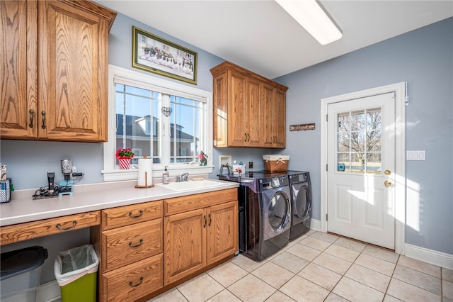 clothes washing area featuring sink, light tile floors, hookup for a washing machine, cabinets, and washing machine and dryer