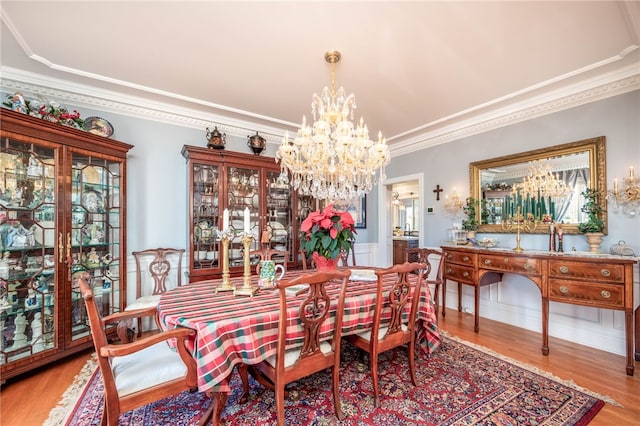 dining room featuring a notable chandelier, crown molding, and light hardwood / wood-style flooring