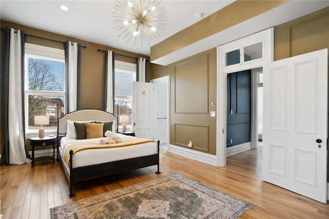 bedroom featuring an inviting chandelier and light hardwood / wood-style floors