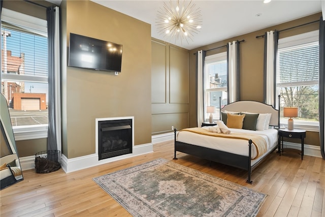 bedroom with a chandelier and light wood-type flooring