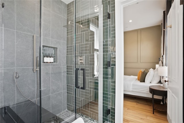 bathroom with wood-type flooring and a shower with door