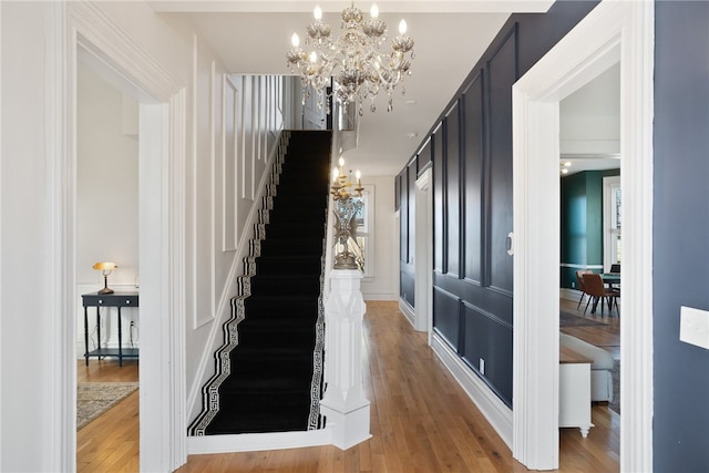 staircase featuring an inviting chandelier and hardwood / wood-style floors