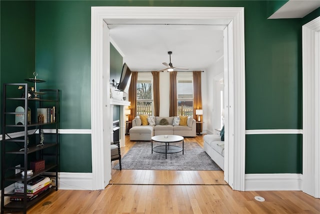 living room with light hardwood / wood-style flooring and ceiling fan