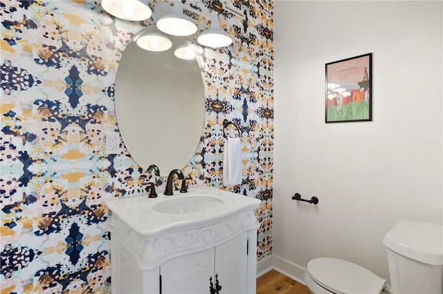 bathroom featuring wood-type flooring, vanity, and toilet