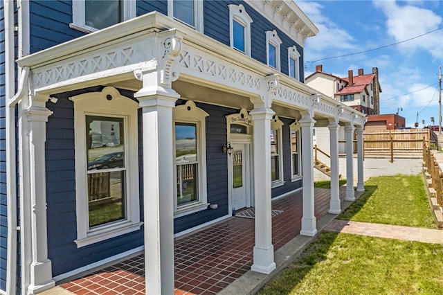 view of side of home featuring a lawn and a porch