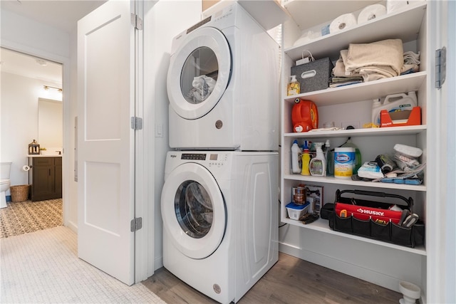 laundry area featuring stacked washer and dryer and light hardwood / wood-style floors