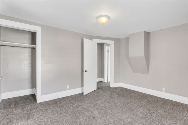 unfurnished bedroom featuring a closet and dark colored carpet